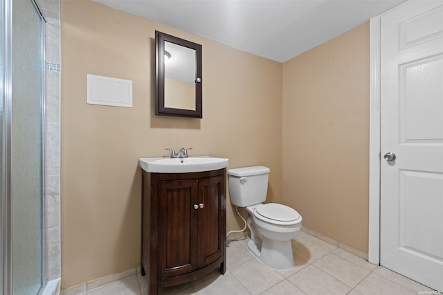 bathroom featuring tile patterned flooring, vanity, toilet, and a shower with shower door