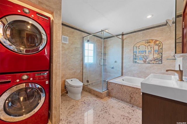 full bathroom with vanity, separate shower and tub, crown molding, stacked washer and clothes dryer, and toilet