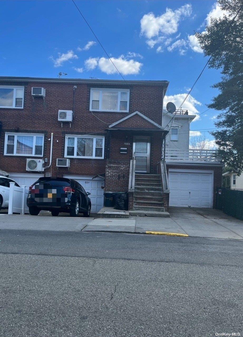 view of front of home featuring a garage and an AC wall unit