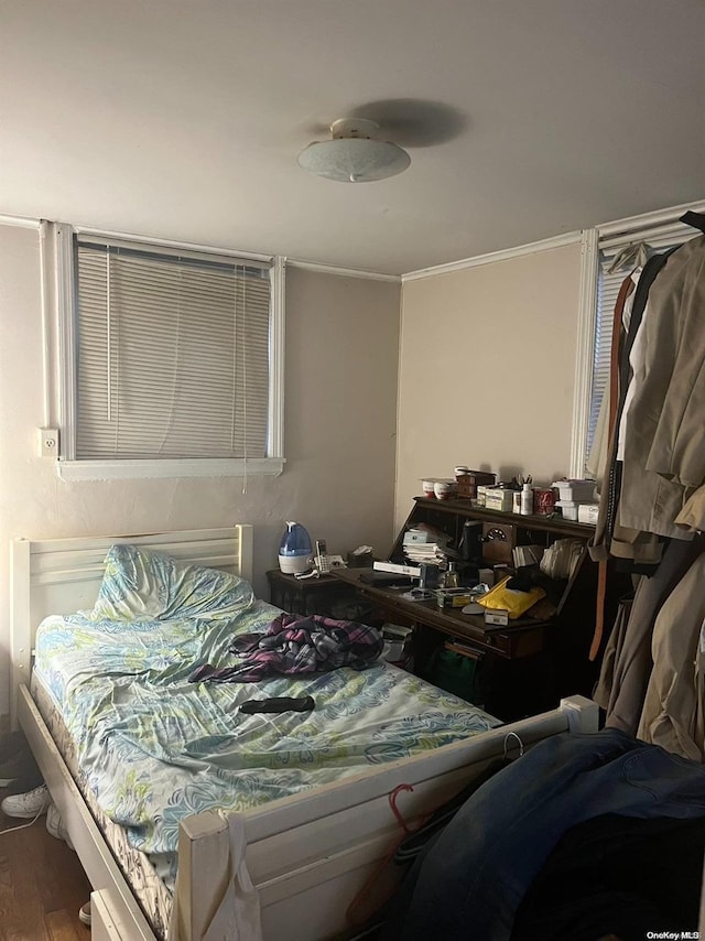 bedroom with hardwood / wood-style flooring and ornamental molding