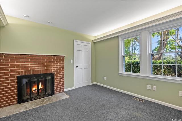 unfurnished living room featuring a fireplace and dark colored carpet