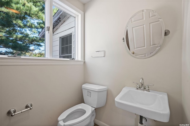 bathroom featuring a healthy amount of sunlight, toilet, and sink