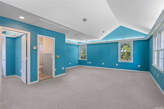 interior space with light carpet and vaulted ceiling