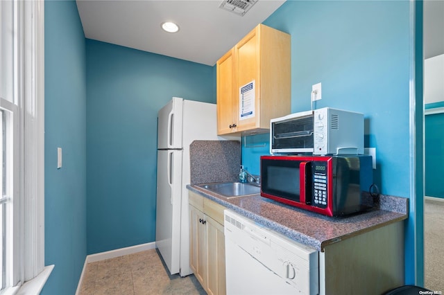 kitchen with tasteful backsplash, white dishwasher, sink, light brown cabinets, and light tile patterned floors