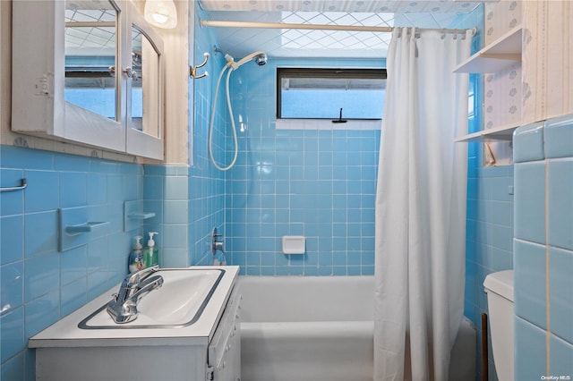 full bathroom with vanity, shower / tub combo, tile walls, and toilet