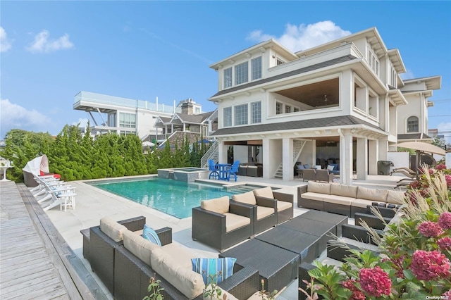 back of house with a swimming pool with hot tub, a patio, and an outdoor hangout area