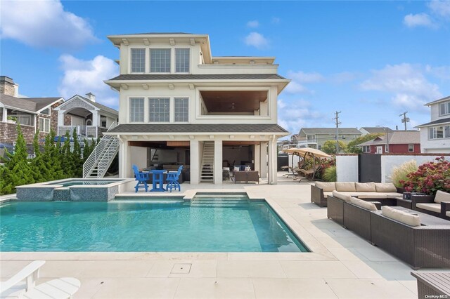 back of house with a swimming pool with hot tub, an outdoor hangout area, and a patio