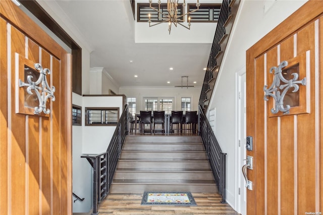 foyer with crown molding and a chandelier