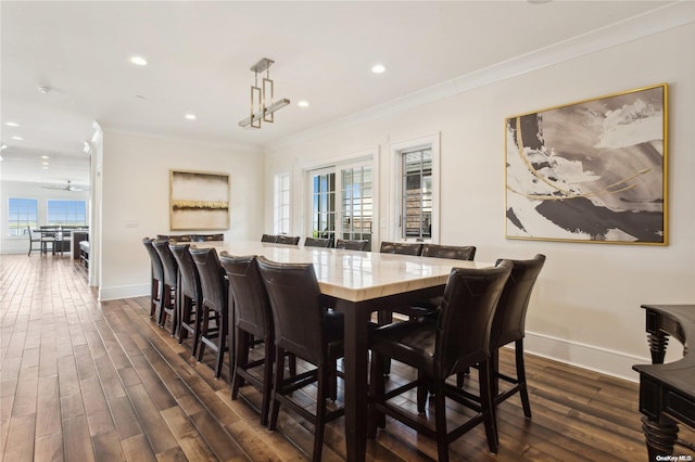 dining area with ceiling fan, crown molding, and dark wood-type flooring