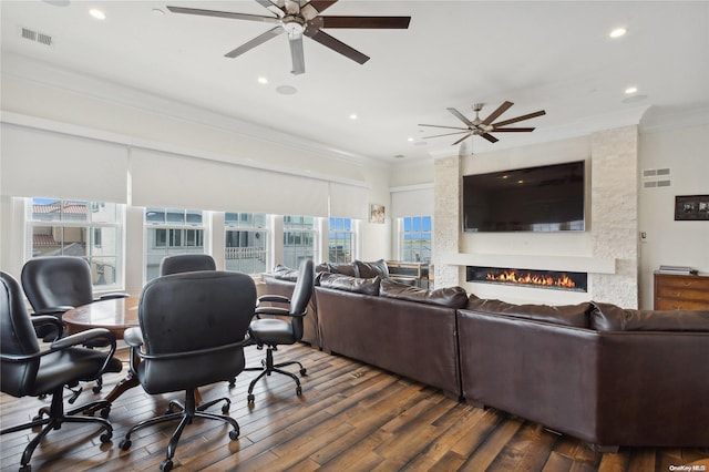 living room with a large fireplace, dark hardwood / wood-style floors, ceiling fan, and ornamental molding