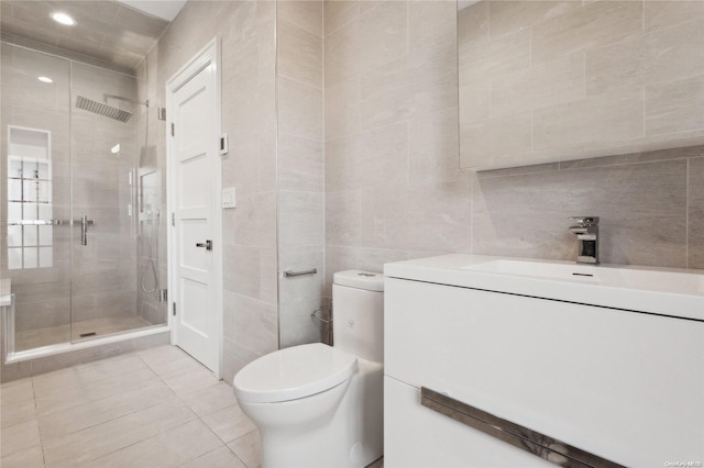 bathroom with an enclosed shower, vanity, tile walls, tile patterned flooring, and toilet