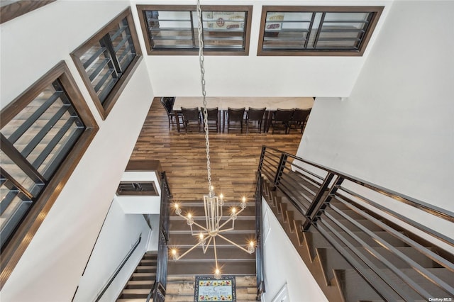 stairway with a towering ceiling and an inviting chandelier