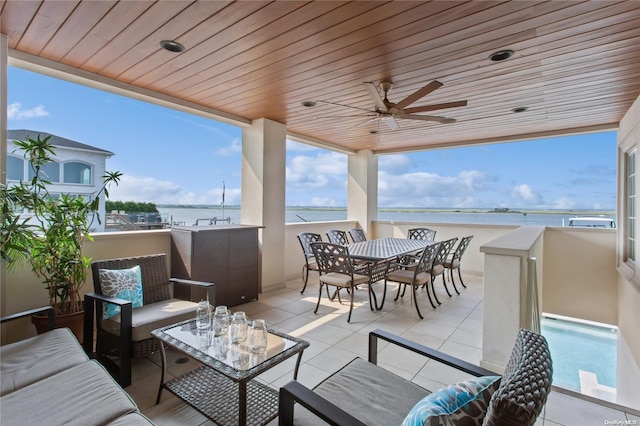 view of patio / terrace with an outdoor living space, a water view, and ceiling fan