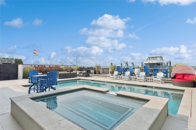 view of swimming pool featuring a patio area and an in ground hot tub