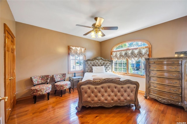 bedroom featuring hardwood / wood-style floors, multiple windows, and ceiling fan