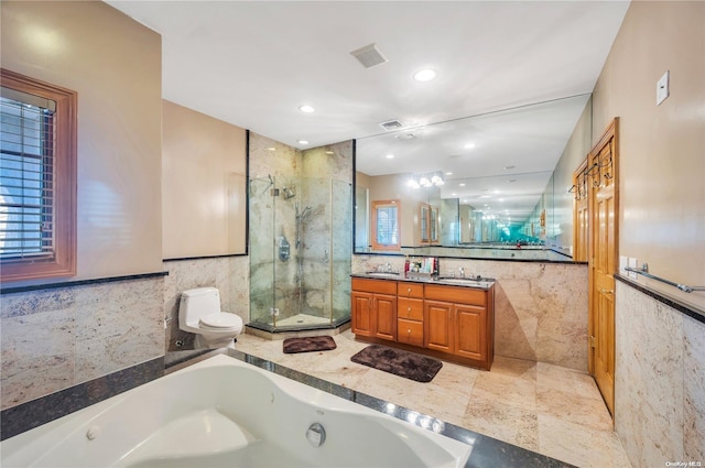 full bathroom featuring vanity, toilet, shower with separate bathtub, and tile walls