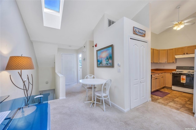 kitchen with white gas range, light carpet, a wealth of natural light, and a skylight