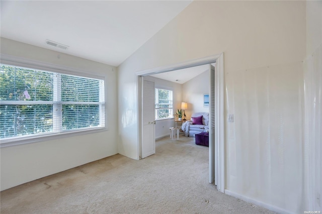 interior space featuring light colored carpet and vaulted ceiling