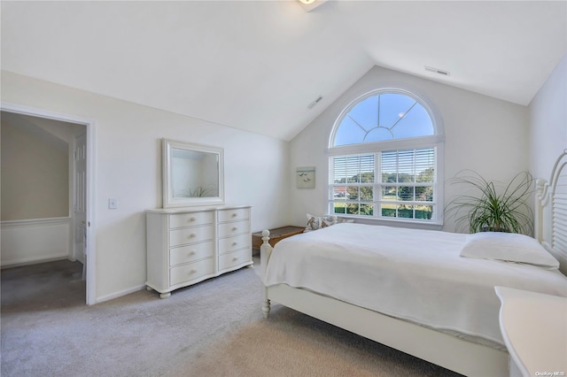 bedroom featuring light colored carpet and vaulted ceiling