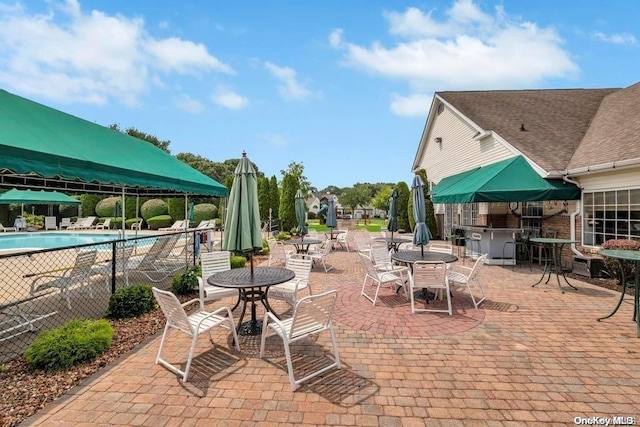 view of patio featuring a bar and a community pool