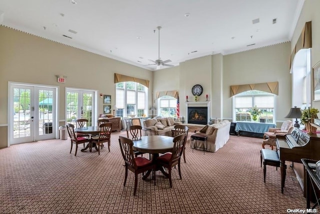 dining space with carpet flooring, ceiling fan, a high ceiling, and french doors