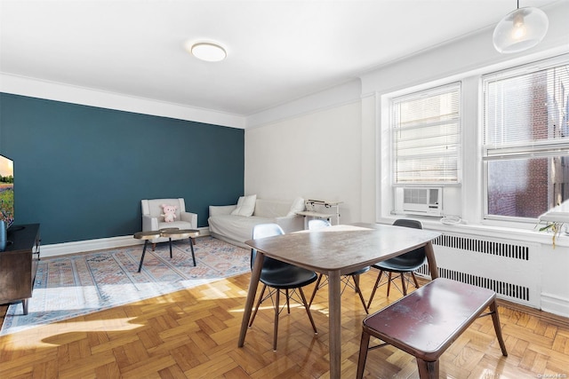 dining space with light parquet flooring, cooling unit, radiator, and ornamental molding