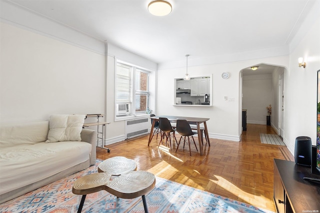 living room with radiator heating unit, light parquet floors, and ornamental molding