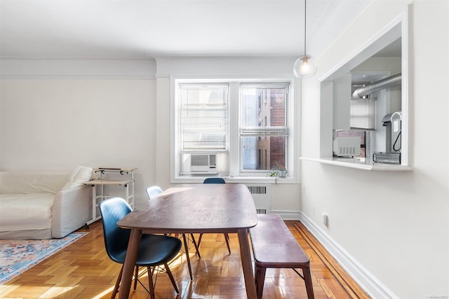 dining area with cooling unit, radiator heating unit, and parquet flooring