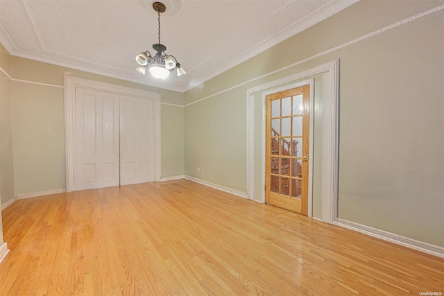 interior space featuring crown molding, light hardwood / wood-style floors, and a notable chandelier