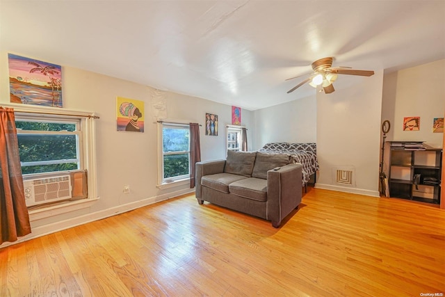 living room with ceiling fan, cooling unit, and light wood-type flooring