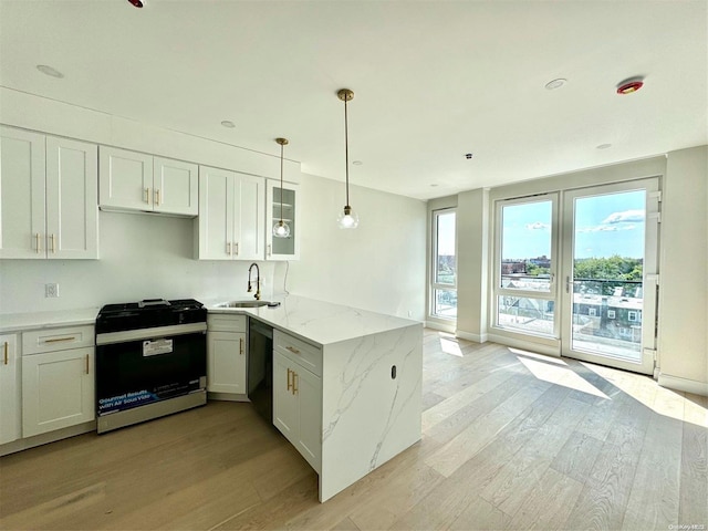 kitchen featuring kitchen peninsula, sink, white cabinetry, and stainless steel range oven