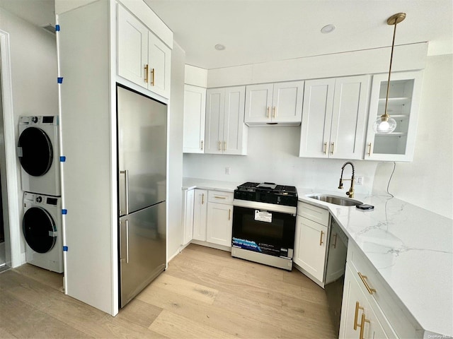 kitchen featuring stainless steel appliances, sink, light hardwood / wood-style flooring, white cabinets, and hanging light fixtures