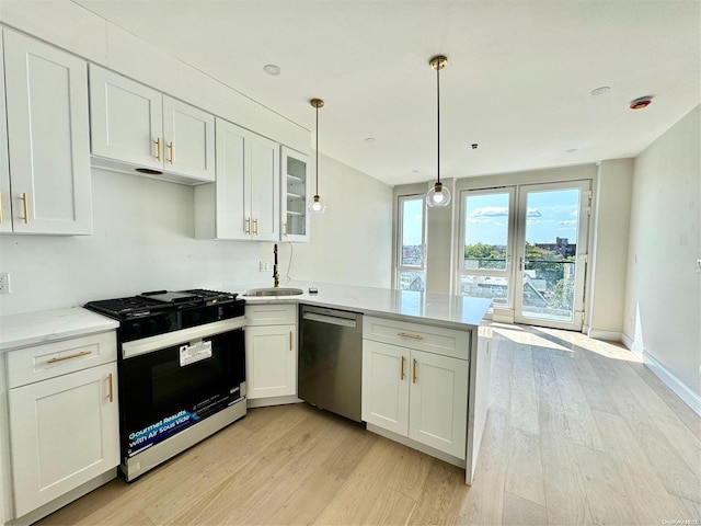 kitchen featuring white cabinetry, stainless steel appliances, kitchen peninsula, pendant lighting, and light hardwood / wood-style floors