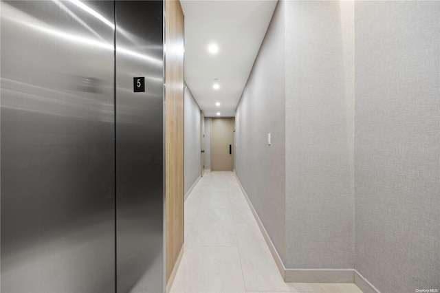 hall featuring light tile patterned floors and elevator