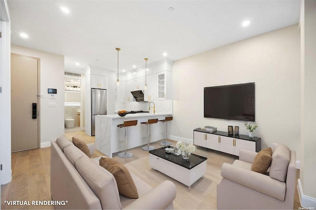 living room with light hardwood / wood-style floors and sink