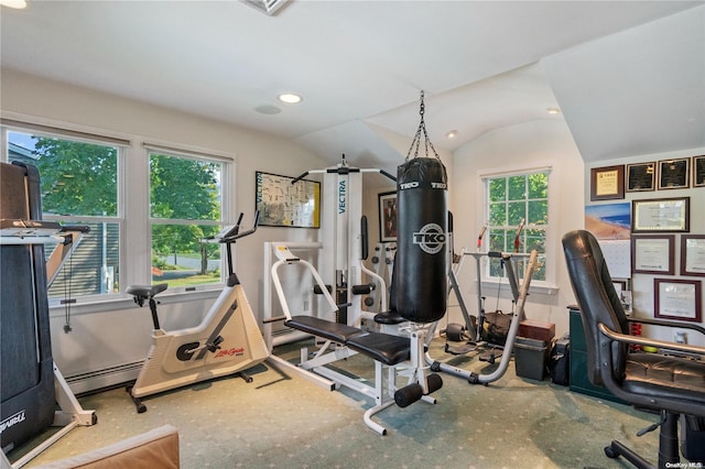 workout area featuring vaulted ceiling and a baseboard heating unit