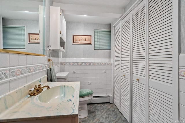 bathroom featuring a baseboard radiator, tile walls, tile patterned flooring, vanity, and toilet