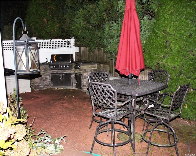 view of patio featuring exterior kitchen and a grill