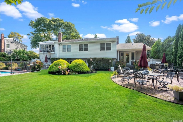 back of property with a patio and a yard