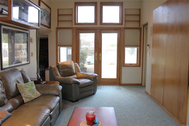 carpeted living room with a towering ceiling and french doors