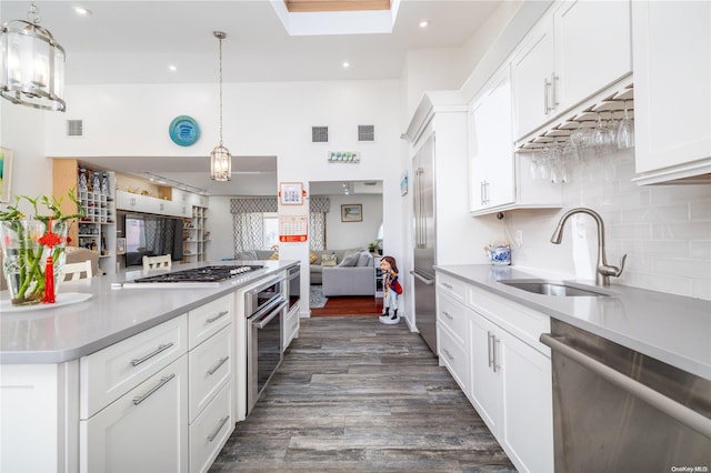 3461 Ocean Ave, Oceanside, NY 11572 - kitchen featuring stainless steel appliances, open floor plan, dark wood-type flooring, white cabinets, and a towering ceiling