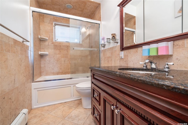 3461 Ocean Ave, Oceanside, NY 11572 - bathroom with baseboard heating, vanity, bath / shower combo with glass door, tile walls, and tile patterned flooring