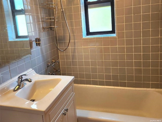 bathroom featuring vanity, tiled shower / bath combo, and a wealth of natural light