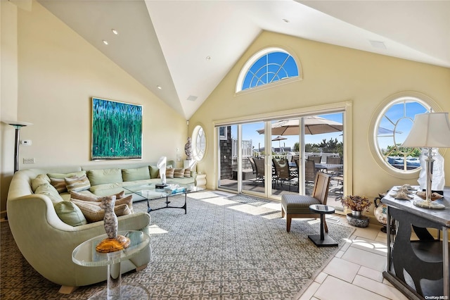 living room featuring plenty of natural light, light tile patterned floors, and high vaulted ceiling