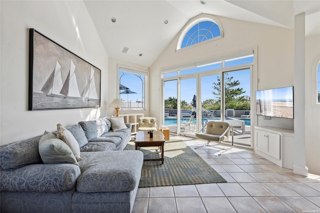 living room featuring light tile patterned floors and high vaulted ceiling