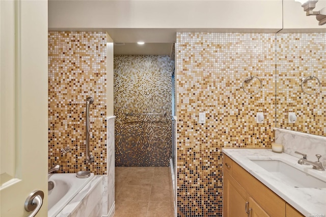 bathroom featuring tile patterned flooring, vanity, tile walls, and tiled shower / bath