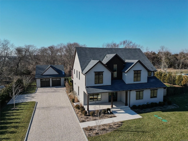 modern farmhouse with a front yard and a garage