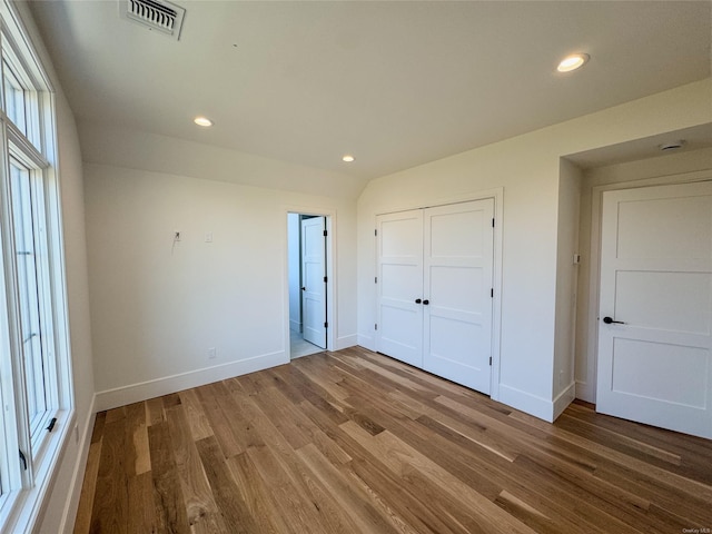 unfurnished bedroom with a closet and hardwood / wood-style flooring