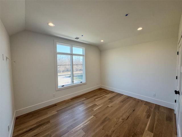 unfurnished room with wood-type flooring and vaulted ceiling