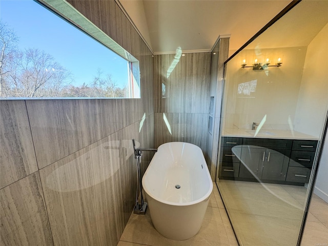 bathroom with a bath, vanity, and tile patterned flooring